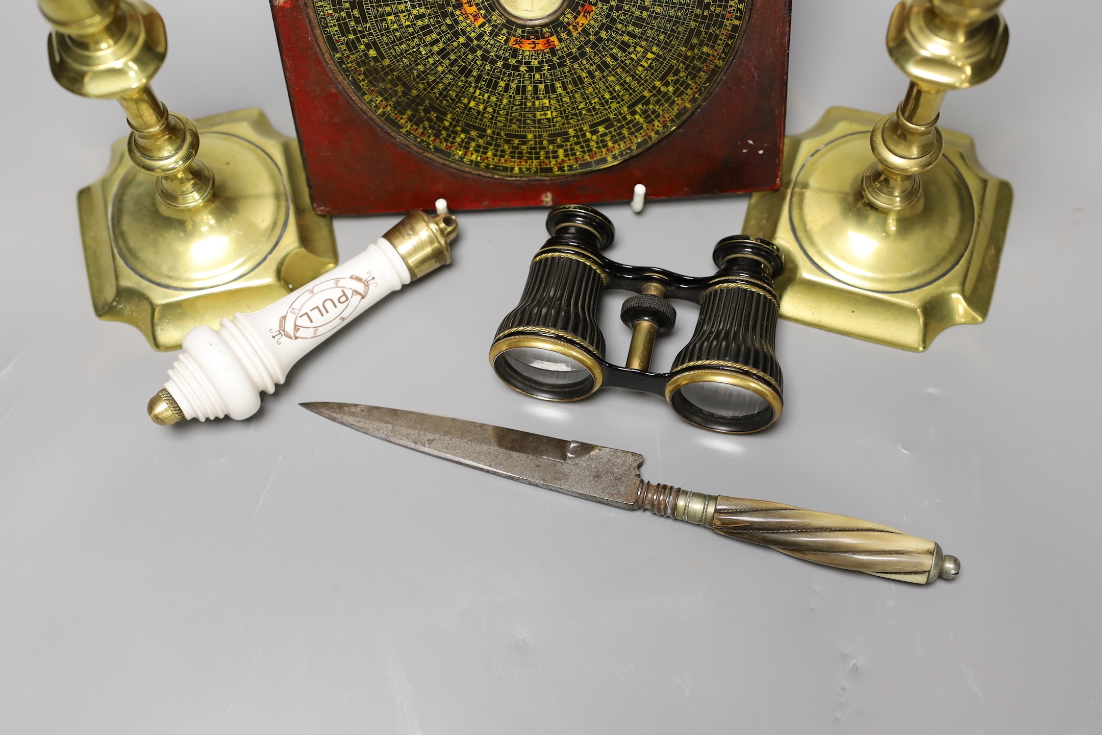 A pair of George III brass candlesticks, southern European knife, a pair of opera glasses, lavatory pull and a Chinese feng shui compass (6)